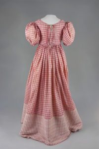 Empirekleid mit rot-weißen Karos. Um 1815. Baumwolle, gewebt.