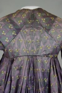 Violettes Empirekleid (Rückendetail). Anfang 19. Jh. Seidenbrokat.