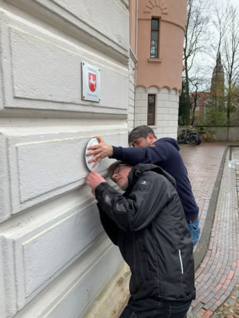 Anbringung des Museumsgütesiegels am rechten Torhaus vor dem Schloss.