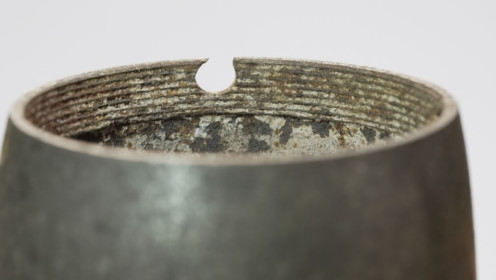 Der vordere Teil eines russischen Schrapnells im Kaliber 7,62 cm. Gut zu sehen ist die ausgerissene Bohrung, in der ein Stift des Verbindungsstücks gesteckt hatte, auf dem der Zünder saß (Inv.-Nr. 02552).