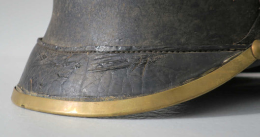 Detail des Augenschirms einer Pickelhaube. 1867 ersetze der runde Augenschirm den eckigen. Neben anderen hilft dieses Detail bei der Datierung der Helme (Inv.-Nr. 03772).